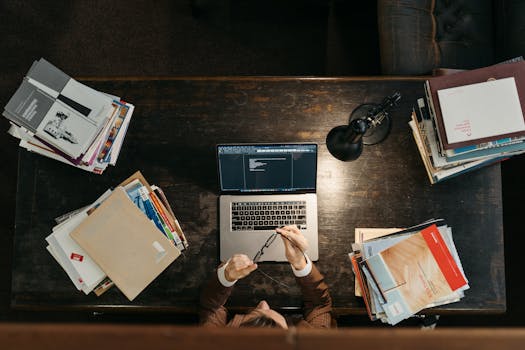 nurse studying with a laptop and textbooks