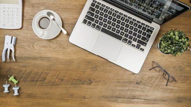 A calculator, notebooks, and a cup of coffee on a desk